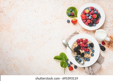 delicious homemade granola or oatmeal with berries for breakfast over white background, top view with copy space - Shutterstock ID 695393119