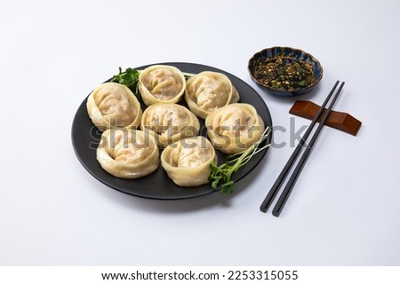 Delicious homemade Korean kimchi dumplings and sauce, white background