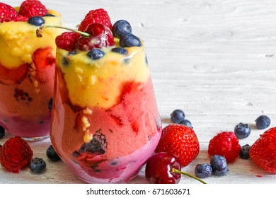 Delicious Homemade Layered Smoothie Dessert Made From Fruits And Berries In Glasses. Mango, Raspberry And Blueberry Smoothie. Close Up. Healthy Breakfast. Close Up