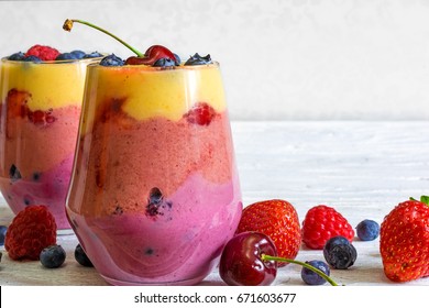 Delicious Homemade Layered Smoothie Dessert Made From Fruits And Berries In Glasses. Mango, Raspberry And Blueberry Smoothie. Close Up. Healthy Breakfast. Close Up