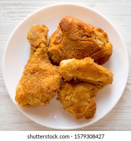 Delicious Homemade Oven Baked Fried Chicken On A White Plate On A White Wooden Background, Top View. Overhead, From Above, Flat Lay. Closeup.