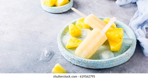 Delicious homemade pineapple popsicles on light blue plate on gray background. Summer food concept with copy space. High angle view. - Powered by Shutterstock