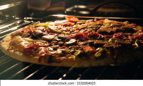 Delicious Homemade Pizza Baking In The Oven. Pepperoni, Jalapeno And Mushroom Pizza, Italian Food On Metal Grate. Food Background.