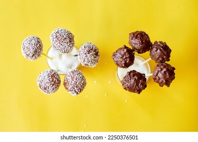 Delicious homemade popcake coconut and dark chocolate cake pops on a yellow background, festival desserts, tasty food - Shutterstock ID 2250376501