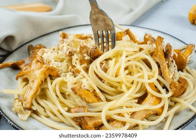 Delicious homemade spaghetti with fried wild mushrooms and cheese, close-up, fork with pasta. - Shutterstock ID 2359978409