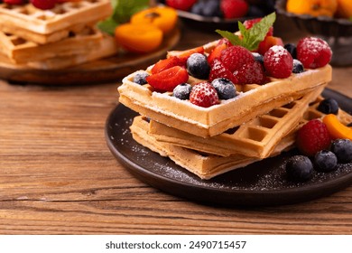 Delicious homemade waffles with whipped cream and fresh fruit. Served on a paper tray or plate. Home production plant. Top or front view.