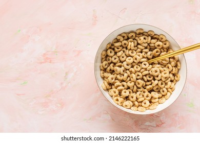 Delicious honey cheerios cereal in a bowl and golden spoon on pink background. Top view, copy space - Powered by Shutterstock