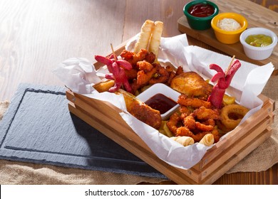 Delicious Hot Crispy Homemade Fresh Fried Plate in Chicken Wings, Sliced Pork Saussage, Fries, Onion Rings and Cheese Stuffed Filo Dough Roll.