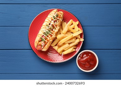Delicious hot dog with bacon, carrot and parsley served on blue wooden table, flat lay