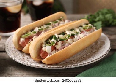 Delicious hot dogs with onion, chili pepper and sauce on wooden table, closeup - Powered by Shutterstock