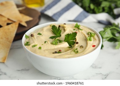 Delicious Hummus With Parsley And Pita Chips On White Marble Table, Closeup