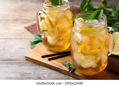 Delicious iced tea on wooden table, space for text