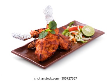 delicious, indian tandoori chicken served with salad isolated on white background