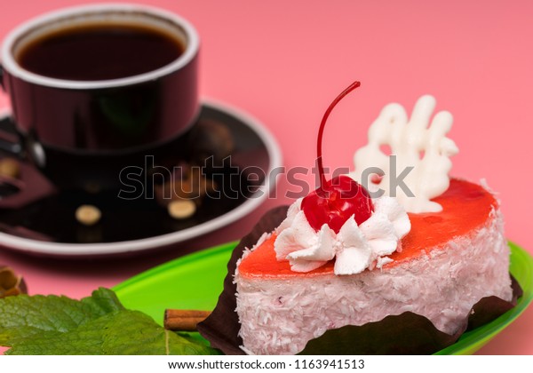 Delicious individual\
gourmet berry cake served with freshly brewed espresso coffee in a\
close up view over\
pink