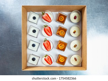 Delicious Italian Dessert Food Delivery In Cardboard Box For Catering Service On Venue.Tasty Sweet Desserts From Pastry Cafe Delivered For Party.Overhead View On Wine Appetizers In Plastic Glasses