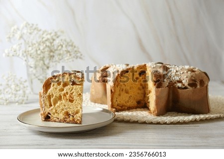 Delicious Italian Easter dove cake (traditional Colomba di Pasqua) on white wooden table, space for text