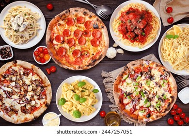 Delicious Italian food table scene. Assortment of pizzas and pastas. Top view on a dark wood background. - Powered by Shutterstock