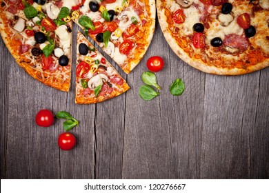 Delicious italian pizzas served on wooden table - Powered by Shutterstock