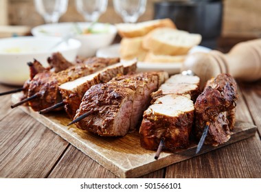 Delicious Juicy Skewered Meat Or Shish Kebabs On Skewers Of Pork Tenderloin In Marinade Of Paprika, Garlic, Thyme And Orange Peel On Wooden Cutting Board. Fragrant And Spicy Dish. Selective Focus