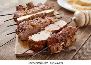 Delicious Juicy Skewered Meat Or Shish Kebabs On Skewers Of Pork Tenderloin In Marinade Of Paprika, Garlic, Thyme And Orange Peel On Wooden Cutting Board. Fragrant And Spicy Dish. Selective Focus