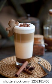 Delicious Layered Cappuccino Or Latte Macchiato Coffee Served In A Long Glass With A Spoon Against A Rustic Wooden Background With Copyspace . Latte Macchiato Coffee Served With Caramel And Cinnamon,