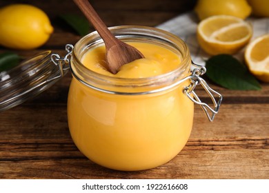 Delicious lemon curd in glass jar on wooden table