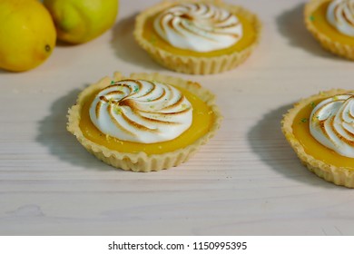 Delicious lemon tartlets with meringue on a white vintage plate. - Shutterstock ID 1150995395