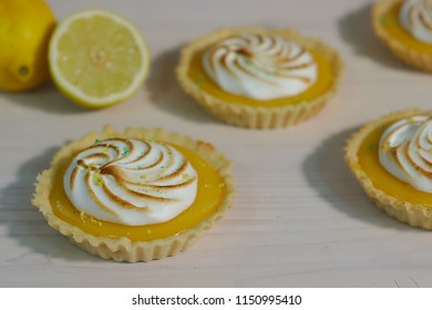 Delicious lemon tartlets with meringue on a white vintage plate. - Shutterstock ID 1150995410