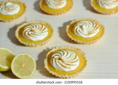 Delicious lemon tartlets with meringue on a white vintage plate. - Shutterstock ID 1150995518