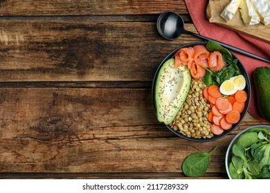 Delicious Lentil Bowl With Carrot, Avocado, Egg And Salmon On Wooden Table, Flat Lay. Space For Text