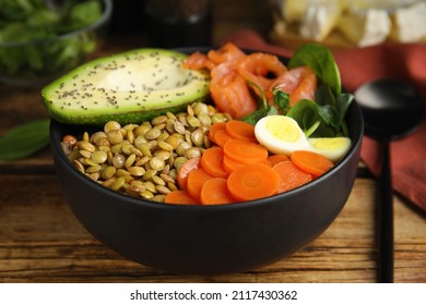 Delicious Lentil Bowl With Carrot, Avocado, Egg And Salmon On Wooden Table