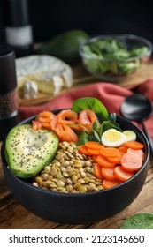 Delicious Lentil Bowl With Carrot, Avocado, Egg And Salmon On Wooden Table