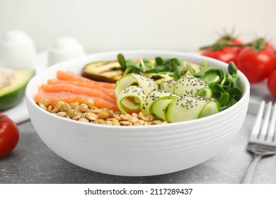 Delicious Lentil Bowl With Salmon, Avocado And Cucumber On Grey Table