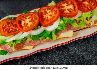 Delicious Long Sandwich With Muenster Cheese, Salami, And Vegetable.