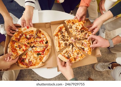 Delicious lunch, snack, fast food. Large group of friends take delicious, fresh and hot slices of pizza from boxes. Top view close-up of men and women's hands taking pieces of pizza to eat them. - Powered by Shutterstock