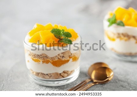 Delicious mango float cake in glasses on wooden board. Filipino sweet cuisine