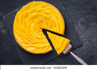 delicious mango tart on dark background. Top view