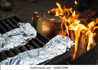 Delicious Meal Wrapped In Tin Foil Cooking Over Fire At Campsite