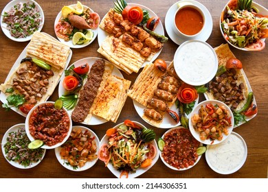 Delicious meat kebab with fresh vegetable salad served with variety of Turkish dishes and appetizers. Top view of assorted Turkish food and meze, tasty and healthy Mediterranean cuisine. - Shutterstock ID 2144306351