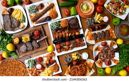 Delicious meat kebab with fresh vegetable salad served with variety of Turkish dishes and appetizers. Top view of assorted Turkish food and meze, tasty and healthy Mediterranean cuisine. - Shutterstock ID 2144306363