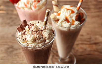 Delicious milkshakes on wooden background - Shutterstock ID 528691546
