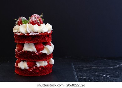 Delicious mini cake red velvet with white cream and strawberries on a saucer on a black wooden background. Food background. Gourmet dessert. Low key. - Shutterstock ID 2068222526
