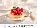 Delicious mini tart made of raspberries and local ingredients. Cummer cake with raspberries.