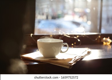 Delicious morning coffee and newspaper near window, indoors