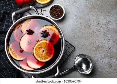 Delicious mulled wine and ingredients on grey table, flat lay. Space for text