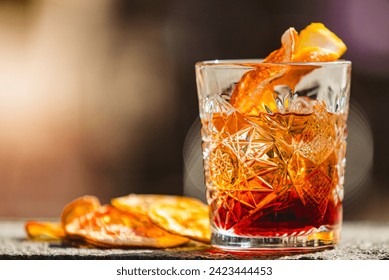 Delicious old fashion cocktail in the etched glass with ice and orange slices, dark wooden background. Shallow dof - Powered by Shutterstock