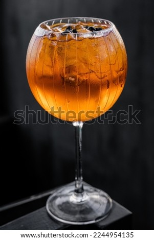 delicious orange drink in an eye-catching round glass on a bar in an upscale restaurant
