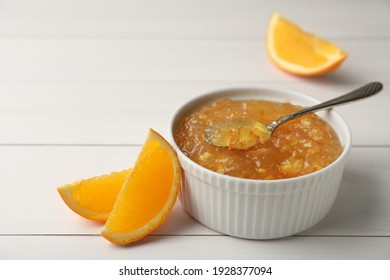 Delicious Orange Marmalade In Bowl With Spoon On White Wooden Table, Space For Text