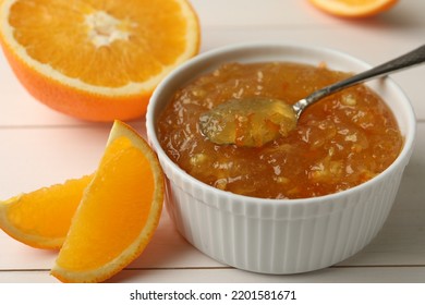 Delicious Orange Marmalade In Bowl With Spoon On White Wooden Table, Closeup