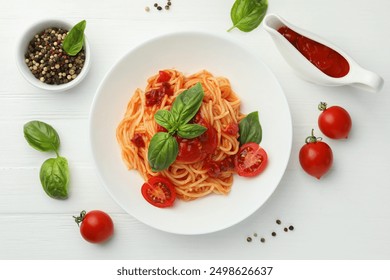 Delicious pasta with tomato sauce, peppercorns, vegetables and basil on white wooden table, flat lay - Powered by Shutterstock